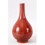 A CHINESE PALE RED GROUND PORCELAIN BOTTLE VASE, the base with six character mark, 26cm high.