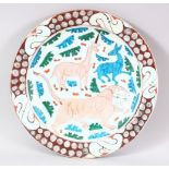 A GOOD LARGE IZNIK POTTERY DISH - decorated in an array of colour depicting animals and flora, 31cm