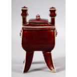 A CHINESE PEACH BLOOM GLAZED TWIN HANDLE LIDDED CENSER - stood on four curving feet with twin