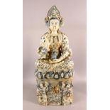 A LARGE CHINESE PORCELAIN FIGURE OF GUANYIN - Seated upon stylized waves with two young
