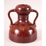 A CHINESE OX RED SPECKLED GLAZE TWIN HANDLE VASE, six character mark to base, 15.5cm high.