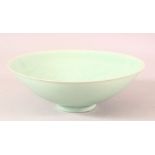 A CHINESE CELADON GLAZED POTTERY BOWL, the interior with sgraffito incised decoration, 20.5cm