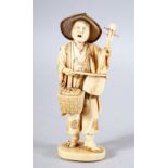 A JAPANESE MEIJI PEPRIOD CARVED IVORY OKIMONO - MUSICIAN - the figure stood holding his basket and