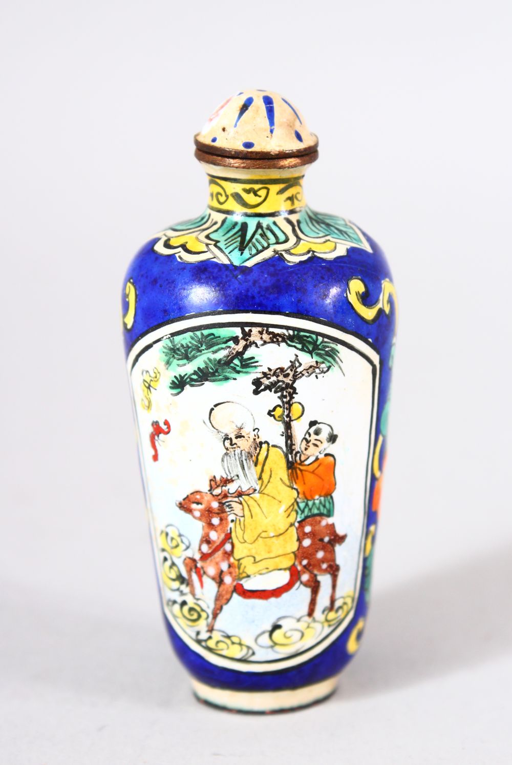 A CHINESE ENAMEL SNUFF BOTTLE - the bottle painted to depict shou lao and his deer holding a staff