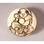 A JAPANESE MEIJI PERIOD CARVED IVORY KAGAMIBUTA NETSUKE - carved with the scene of a boy seated -