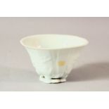 A CHINESE BLANC DE CHINE PORCELAIN LIBATION CUP, with moulded floral decoration, 9cm wide.