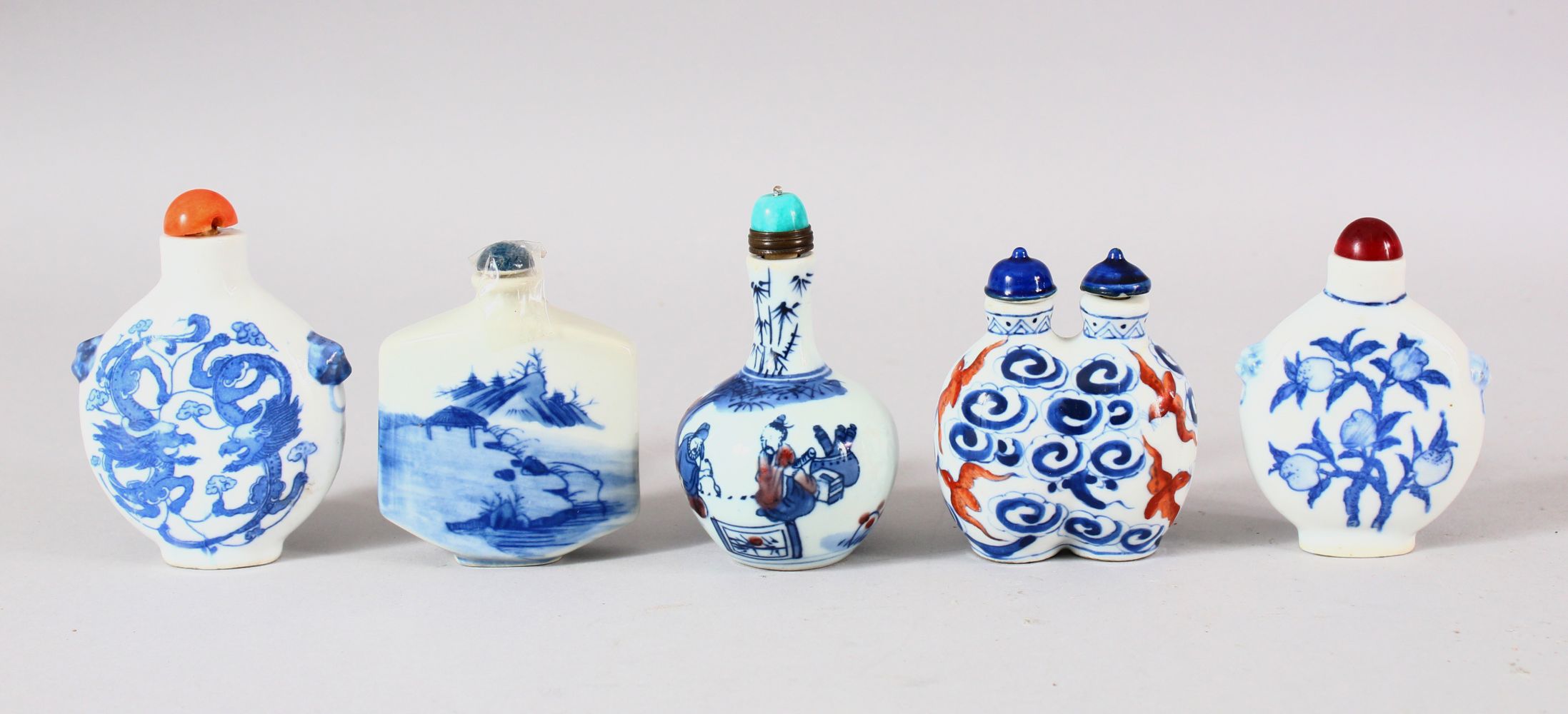 A MIXED LOT OF 5 CHINESE BLUE & WHITE PORCELAIN SNUFF BOTTLES - each with a varied subject, peach