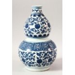 A CHINESE BLUE AND WHITE DOUBLE GOURD VASE, painted with lotus flowers, 27cm high.