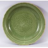 A CHINESE LONGQUAN OLIVE GREEN GLAZED PORCELAIN DISH - the interior carved with a beast, cloud and