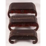 A GRADUATED SET OF THREE CHINESE HARDWOOD STANDS, each with curving ends and carved decoration,