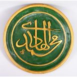 AN ISLAMIC CARVED WOODEN CALLIGRAPHY PANEL, The script in relied and gilded upon a green ground.