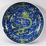 A CHINESE BLUE GROUND PORCELAIN DRAGON DISH, the centre painted with a dragon and the pearl of