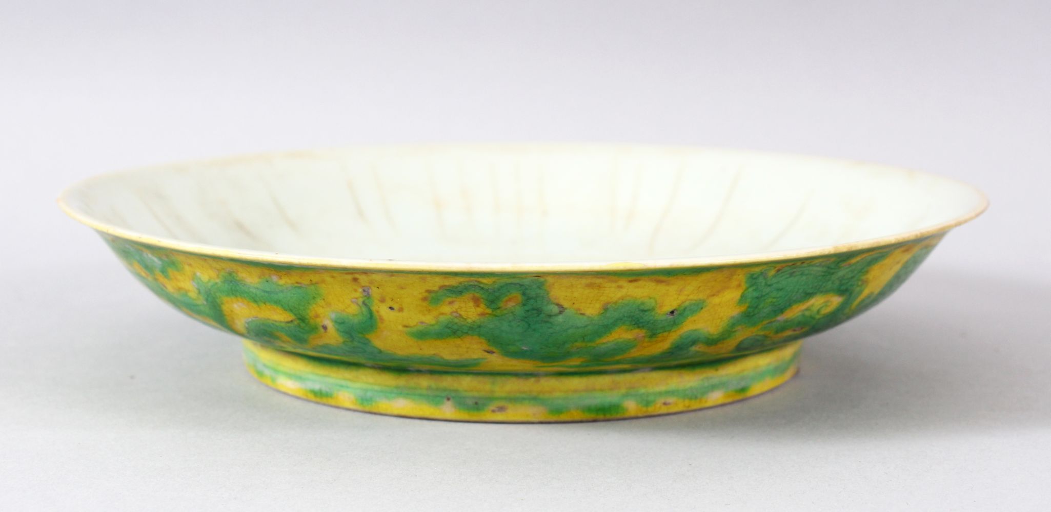 A CHINESE YELLOW GROUND PORCELAIN DRAGON DISH, the base with six character mark, 20cm diameter.