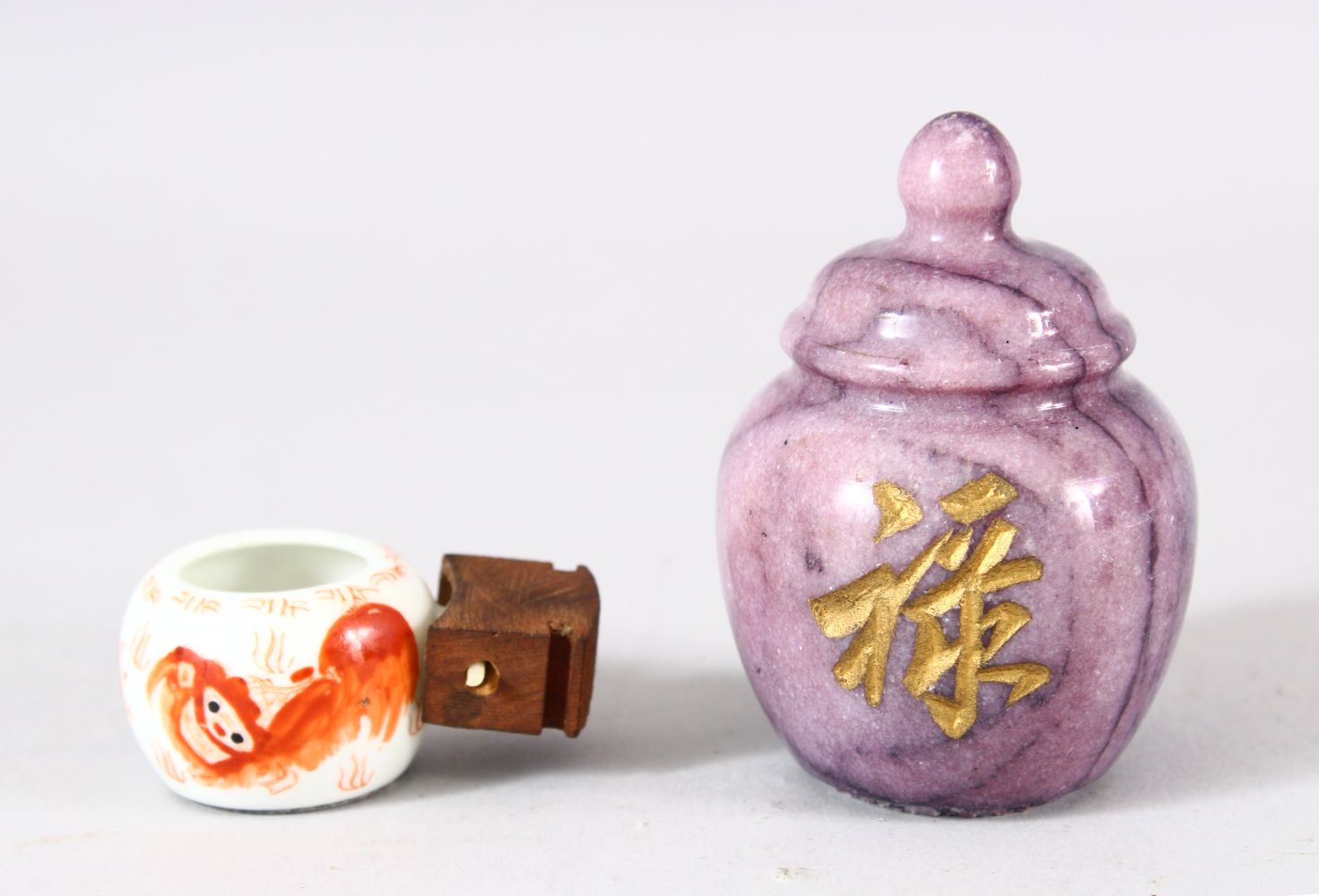 A CHINESE CARVED AMETHYST CALLIGRAPHIC OBJECT & IRON RED PORCELAIN CUP - A miniature iron red