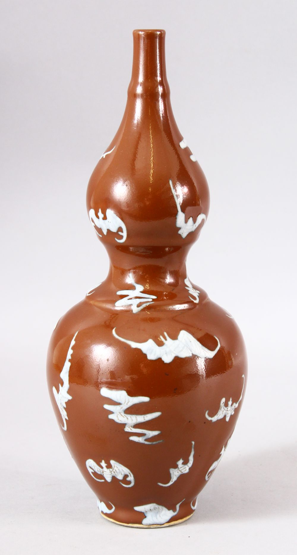 A CHINESE BROWN GLAZED DOUBLE GOURD PORCELAIN BAT VASE - decorated with many bats upon a cafe au