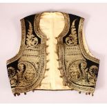 AN OTTOMAN EMBROIDERED BALKANS CHILD WAISTCOAT - with a black ground and gold coloured thread.