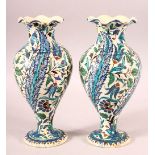 A PAIR OF TURKISH OTTOMAN KUTAHIYA POTTERY VASES, painted with decorative floral sprays, 26.5cm