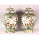 A PAIR OF CHINESE FAMILLE VERTE PORCELAIN JARS AND COVERS, each painted with two large panels