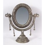 A GOOD INDIAN EMBOSSED WHITE METAL MORROR ON STAND - the mirror with twin elephant heads