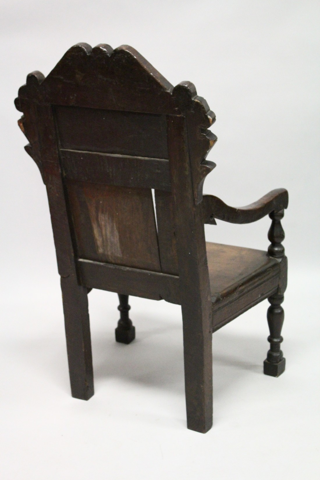 AN 18TH CENTURY OAK ARMCHAIR, with carved cresting rail and panelled back, solid seat and curving - Image 4 of 4