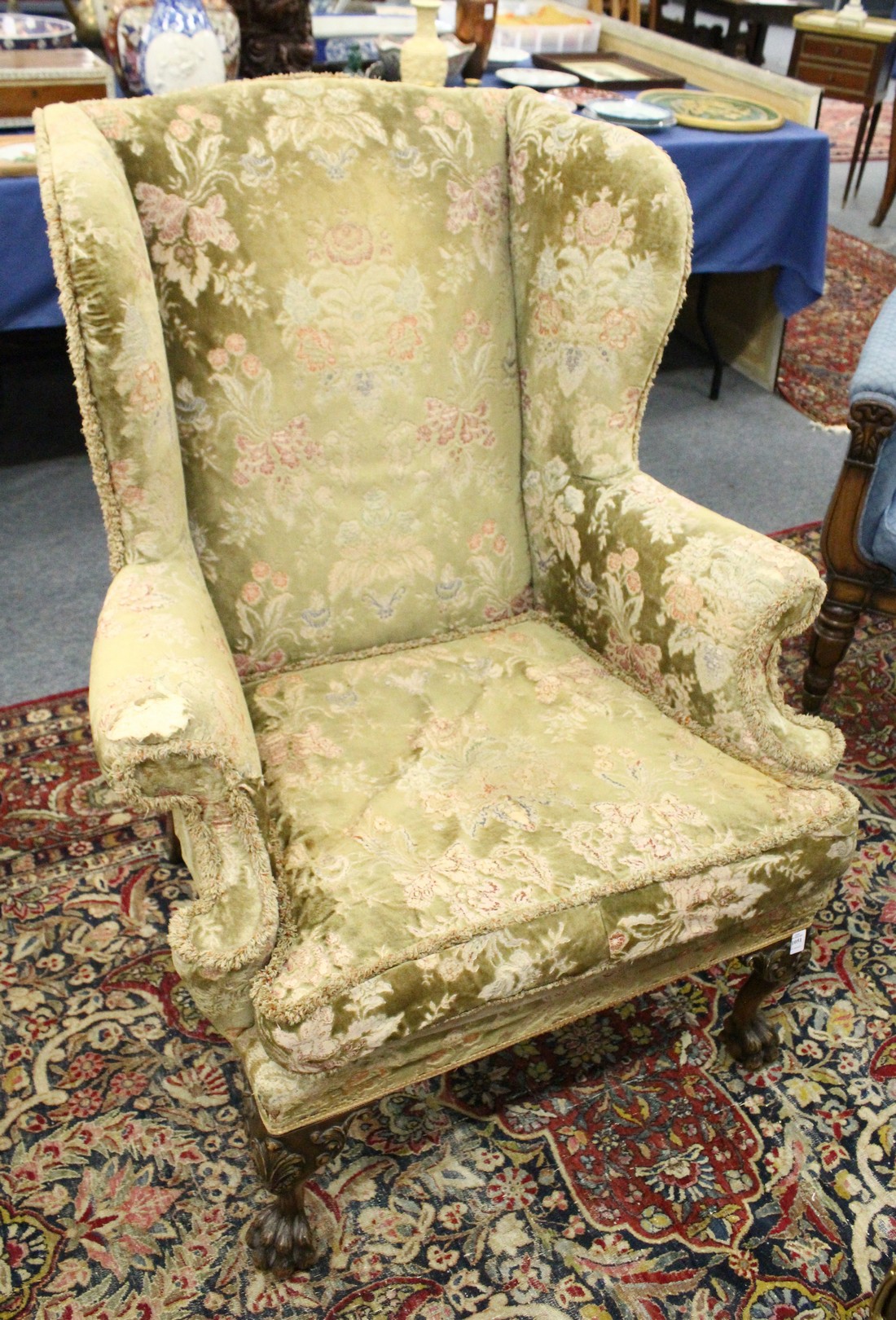 A GEORGE III DESIGN WING ARMCHAIR with floral decoration and velvet upholstery on carved cabriole