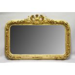 A LARGE DECORATIVE GILT FRAMED OVERMANTLE MIRROR, with ornate cresting and floral decorated frame.