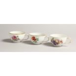 THREE 19TH CENTURY BERLIN CUPS painted with flowers. Septre mark in blue.