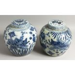 A PAIR OF CHINESE BLUE AND WHITE GINGER JARS AND COVERS with fish. 12ins high.