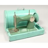 A CHILD'S TIN PLATE SEWING MACHINE AND COVER 10ins long