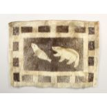 AN INUIT SEALSKIN WALL HANGING, depicting a polar bear hunting a seal. 21.5ins x 15.5ins.