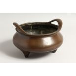 A LARGE CHINESE BRONZE TWO HANDLED CENSER on four feet.