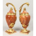 A GOOD PAIR OF RED MARBLE URNS with ormolu mounts and cherubs on square bases. 13ins high.