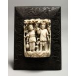 A GOOD CARVED AND PIERCED EUROPEAN IVORY OF A MAN AND A WOMAN IN AN ARBOUR. 3.5ins x 2.5ins on a