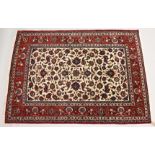 A GOOD PERSIAN ISFAHAN RUG, central cream ground panel with a red ground floral border. 7ft 3ins x
