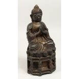A BRONZE SEATED GOD, calligraphy on its back, 11ins high