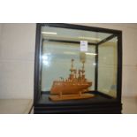 A Japanese carved box wood model of a gun ship, in a display case.
