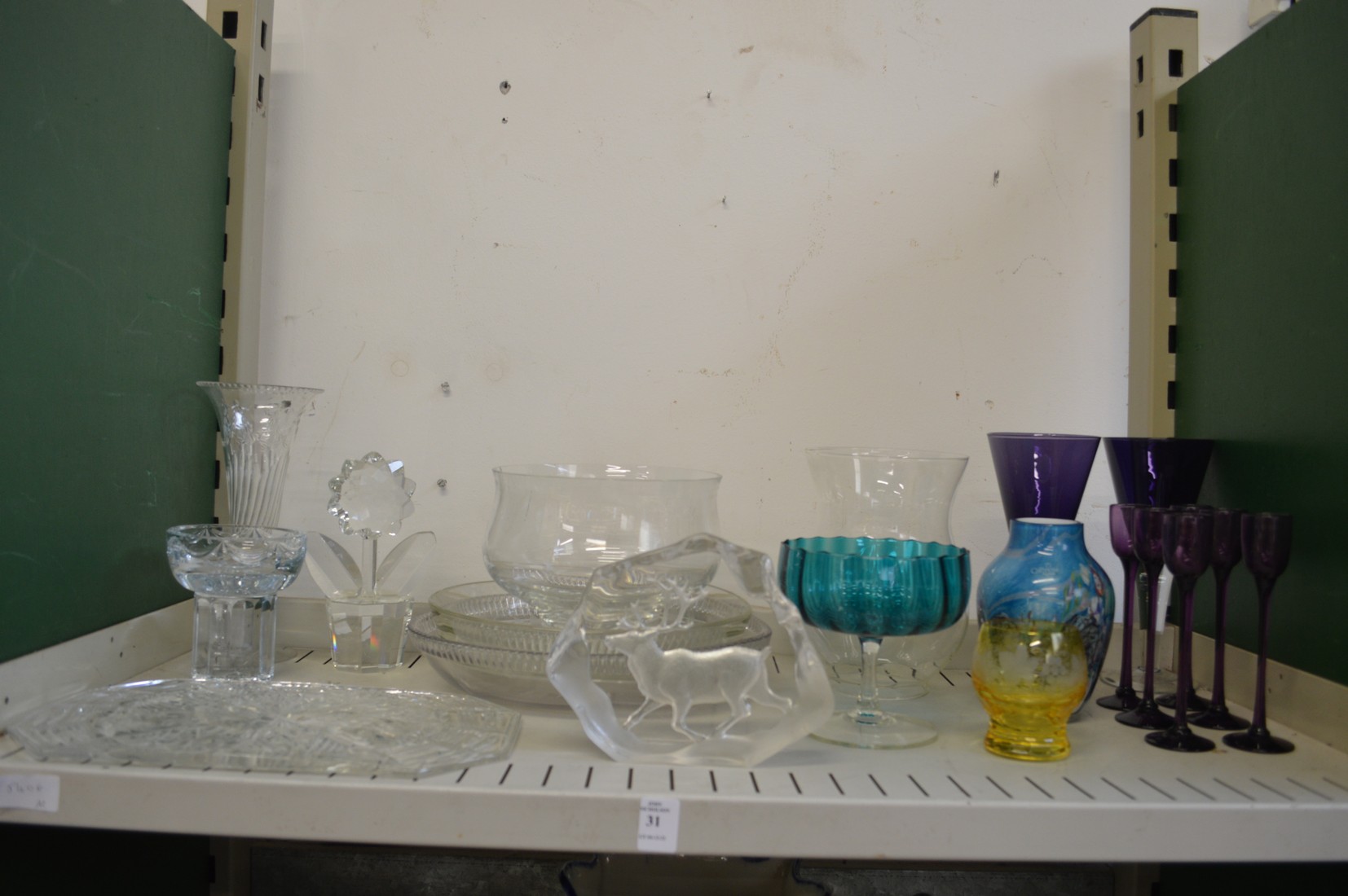 A shelf of decorative and household glass.