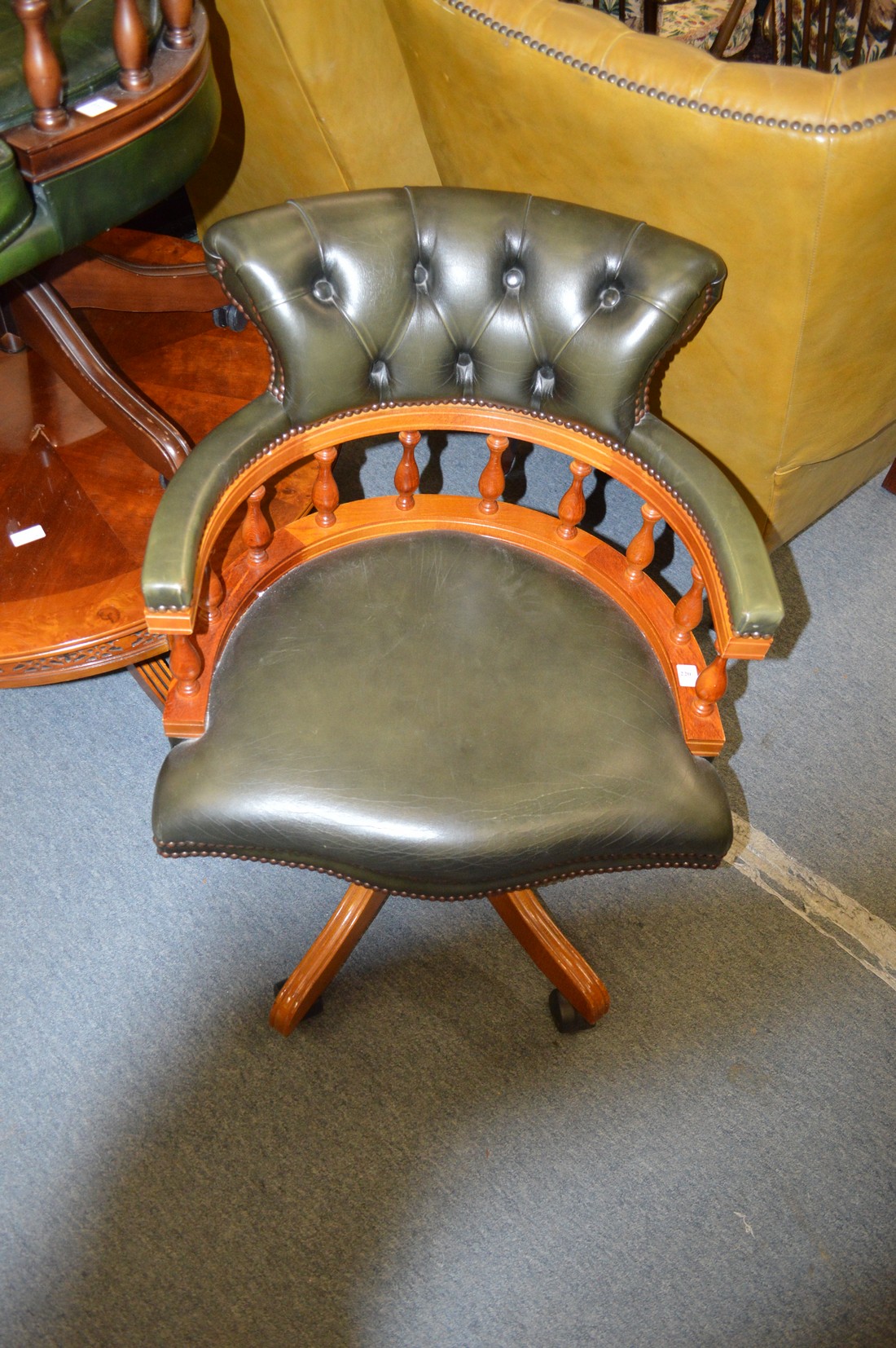 A good modern green leather upholstered and beech framed revolving desk chair.