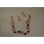 A rose quartz necklace and earrings.