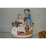 A 19th century porcelain group of a young boy and girl with a goat and grapes.