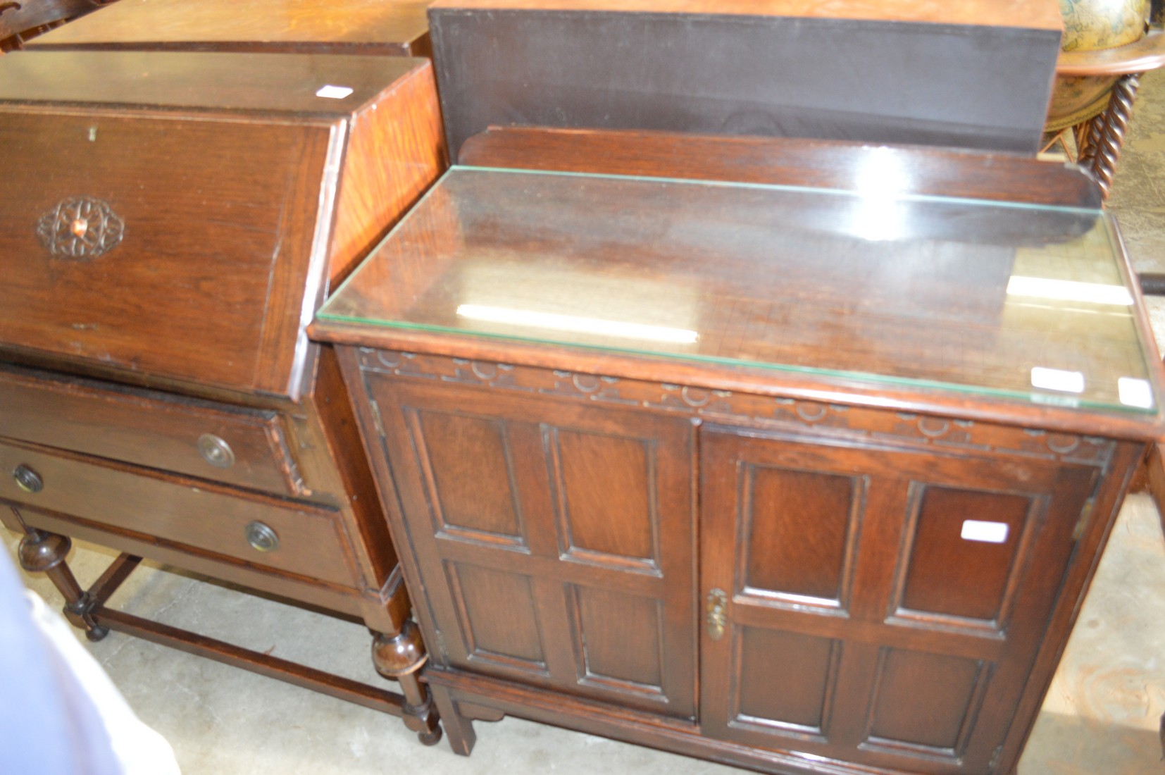 An oak two door cupboard and an oak bureau.