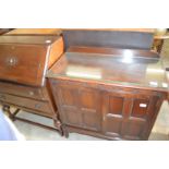 An oak two door cupboard and an oak bureau.