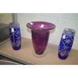 A large amethyst tinted glass vase and a pair of blue Bohemian glass vases.