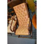 A brown button leather upholstered mahogany framed rocking chair.
