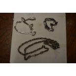 A heavy silver bracelet and similar necklaces.