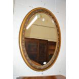 A gilt framed oval wall mirror.