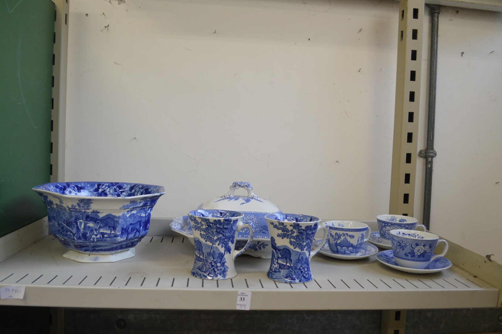 Two shelves of blue and white china together with a floral decorated trio.