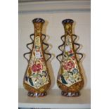 A pair of Hungarian pottery vases with moulded handles and floral decoration (one restored).