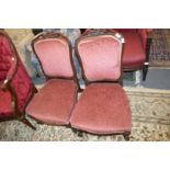 A pair of Victorian carved rosewood framed upholstered bedroom chairs.