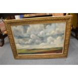 A barren landscape with stormy clouds, oil on board, in a decorative gilt frame.